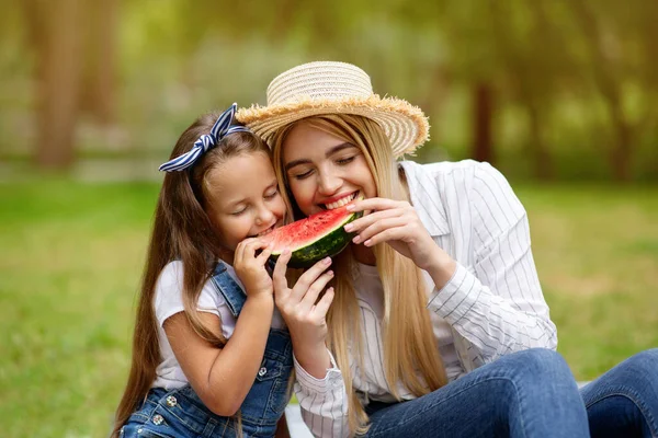 Glädjande mor och liten dotter äter vattenmelon njuter picknick utanför — Stockfoto