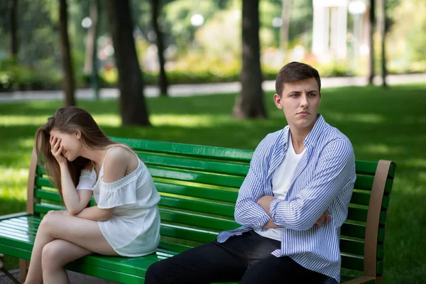 Frustré jeune homme et pleurer fille après combat assis sur le banc au parc — Photo