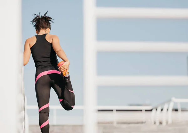 Desporto ativo ao ar livre. Africano americano mulher em esportes uniforme fazendo treino para pernas — Fotografia de Stock