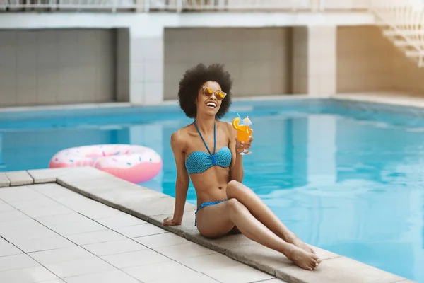 Bella ragazza afroamericana godendo il suo cocktail rinfrescante vicino alla piscina all'aperto, spazio copia — Foto Stock