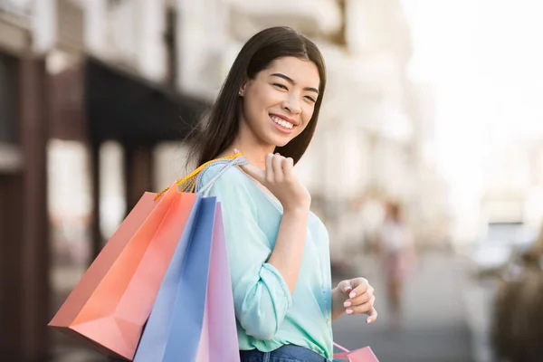 Shoppingälskare. Porträtt av Happy Girl Posing With Bright Shopper väskor utomhus — Stockfoto
