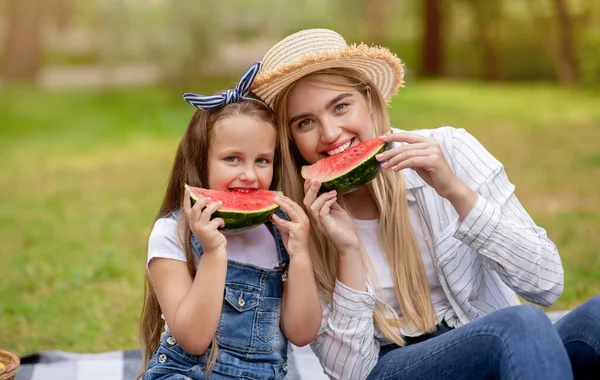 Kvinnan och hennes lilla dotter äter vattenmelon på landet — Stockfoto