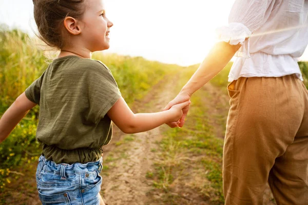 Mutter nimmt ihre kleine Tochter sanft an der Hand — Stockfoto