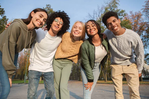 Engraçado adolescentes multiétnicos sorrindo para a câmera ao ar livre — Fotografia de Stock