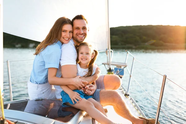 Família sentada no iate abraçando desfrutar de viagens marítimas ao ar livre — Fotografia de Stock
