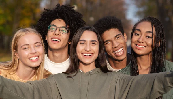 Sonriente adolescente amigos tomando selfie mientras caminando en parque —  Fotos de Stock