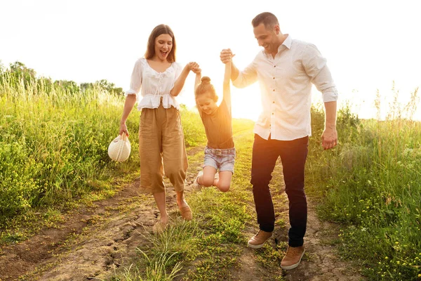 여름 들판에서 함께 걷는 행복 한 부모와 아기 — 스톡 사진