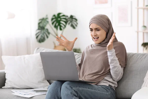 Computerprobleme. Wütende Araberin hat Probleme mit Laptop zu Hause — Stockfoto