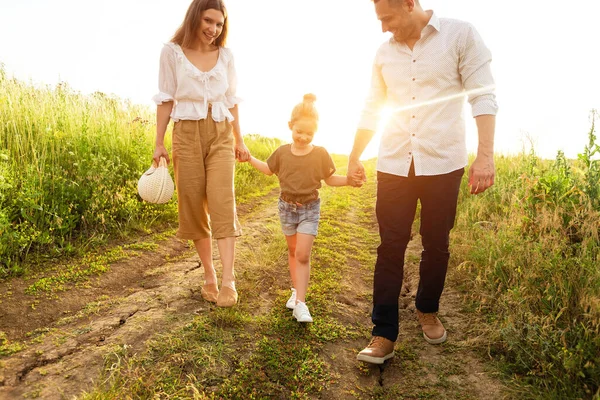 Szczęśliwi rodzice i dziecko spacerujące razem latem na zewnątrz — Zdjęcie stockowe