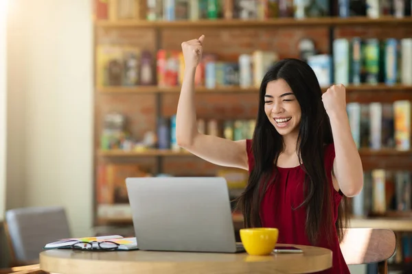 Lucky Day. Emocionado chica asiática celebrando el éxito con el ordenador portátil en el café — Foto de Stock