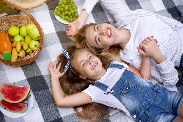 Lycklig mor och dotter ligger på rutig i parken, Ovanför-Visa — Stockfoto