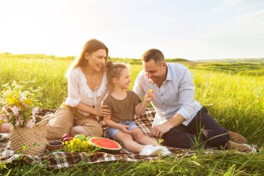 Küçük kız babasını üzümle besliyor.