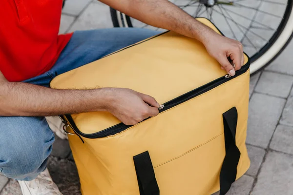 Velká žlutá termální taška. Kurýr balí zboží do batohu pro klienta — Stock fotografie