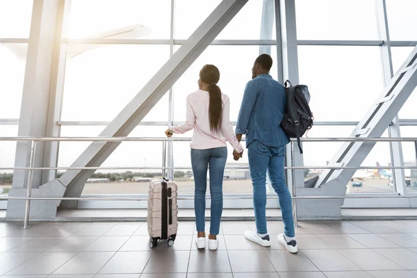 Romantic Travel. Black couple in love looking at window in airport — Stock Photo, Image