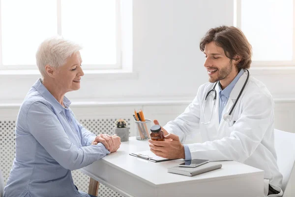 Professionele arts vertellen pillen schema aan senior patiënt — Stockfoto