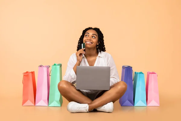 Ragazza shopping online con computer portatile seduto su sfondo beige — Foto Stock