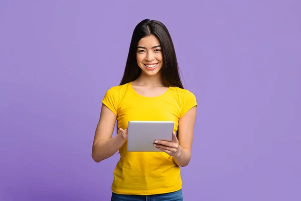 Öğrenciler için uygulama. Güzel Asyalı kız mor arka planda dijital tablet kullanıyor — Stok fotoğraf