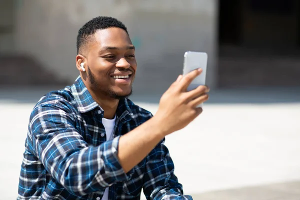 Portret czarnego faceta oglądającego wideo na komórce — Zdjęcie stockowe