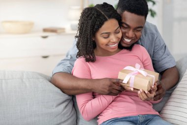 Yıldönümü sürprizi. Sevgi dolu siyah adam, mutlu karısına hediye veriyor.