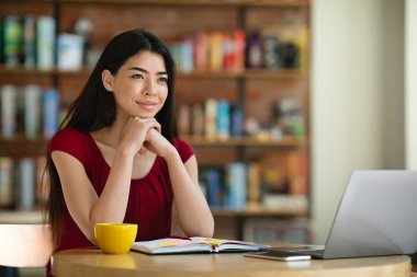 Hayal kuruyorum. Kafe masasında oturan Asyalı serbest bir kızın portresi.