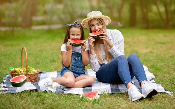 Söt mor och dotter äter vattenmelon sitter på rutig utomhus — Stockfoto