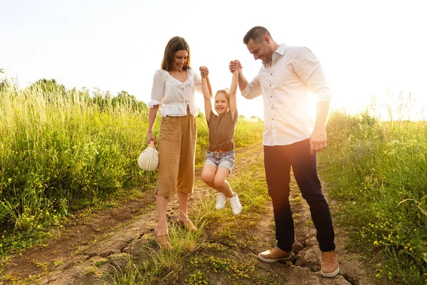 Glückliche Eltern und Kind beim gemeinsamen Spaziergang im Sommerfeld — Stockfoto