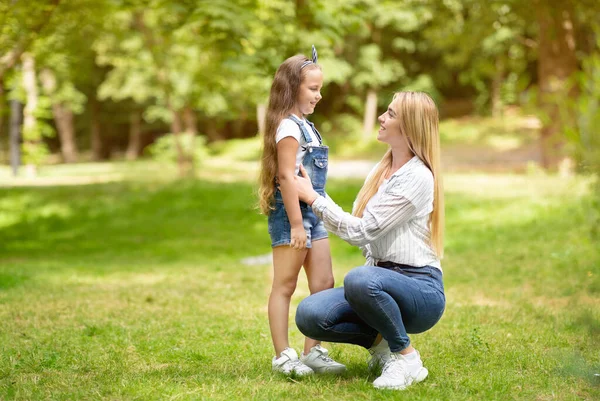 Šťastná matka a malá dcera mluví procházky v parku venku — Stock fotografie