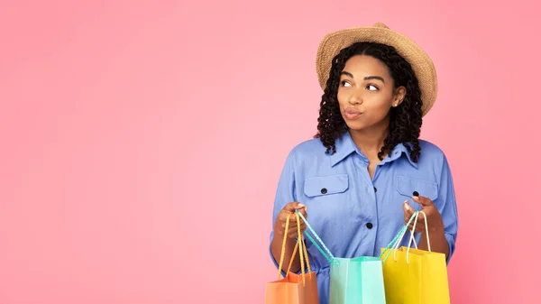 Negro dama celebración Shopper bolsas mirando a un lado posando en estudio —  Fotos de Stock