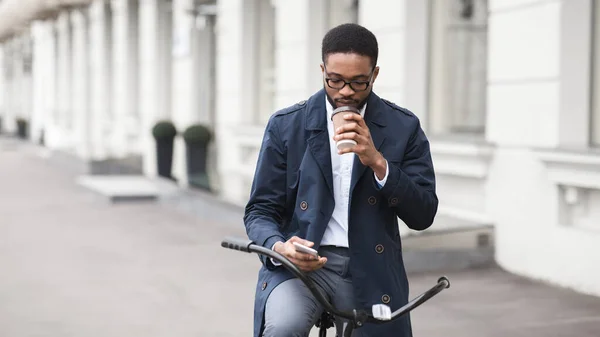 Guapo hombre de negocios mensajes de texto en el teléfono beber té — Foto de Stock