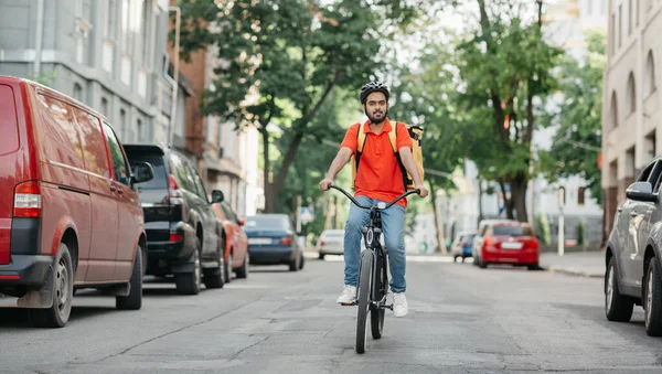 Servicio de entrega urgente. Ciclista con casco y mochila amarilla paseos por carretera — Foto de Stock