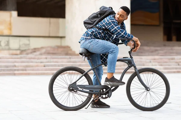 Retrato de un negro montando su bicicleta en la ciudad — Foto de Stock