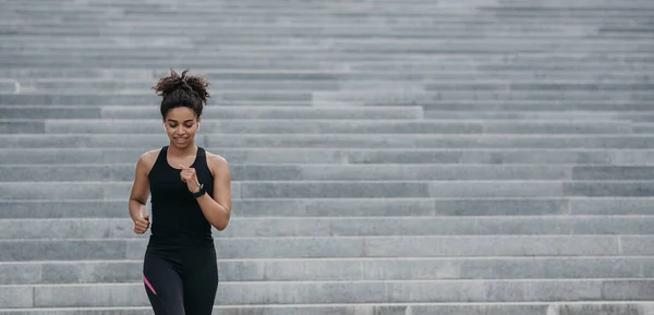 Güçlü atletik kadın koşuyor. Spor giyim sektöründe spor ayakkabılı mutlu bir kız merdivenlerde kardiyo çalışması yapıyor. — Stok fotoğraf