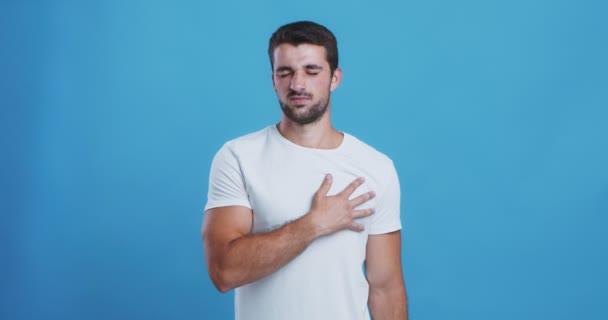 Joven que sufre de insuficiencia cardíaca, masajeando su pecho — Vídeo de stock