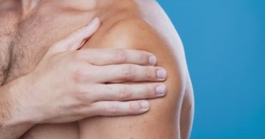 Acı çeken omzunu muayene eden adama yaklaş.