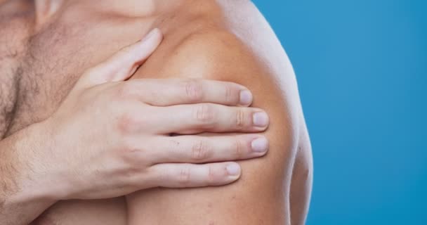 Nahaufnahme eines Mannes, der seine nackte schmerzhafte Schulter untersucht — Stockvideo