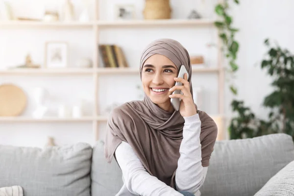 Panggilan Lama Ditunggu. Happy Muslim Girl In Hijab mengadakan percakapan telepon di rumah — Stok Foto