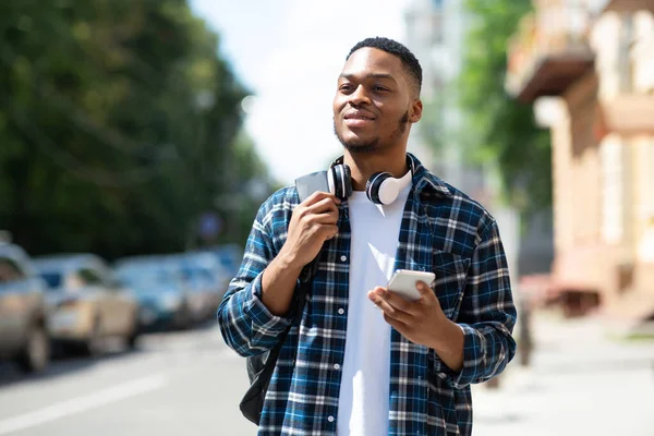 Retrato de afro homem segurando telefone, andando pela rua — Fotografia de Stock