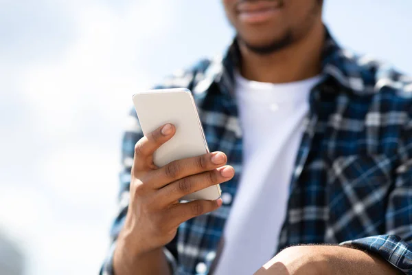 Portrait of african american guy texting sms on smart phone — Stock Photo, Image