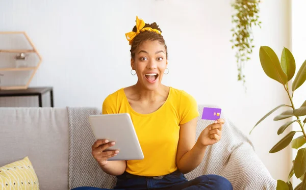 Black lady holding tablet and credit card at home — Stock Photo, Image