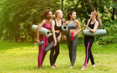 Yoga dersinden sonra arkadaşça sohbet eden çeşitli genç kadınların tam boy portresi, boşluğu kopyala