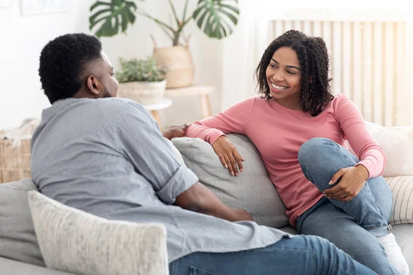 La comunicación en las relaciones. Loving Black Pareja charlando juntos en el sofá en casa —  Fotos de Stock