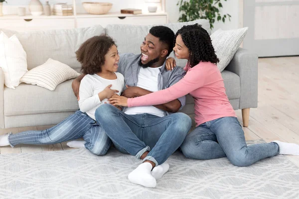 Familie tijdverdrijf. gelukkig zwart ouders spelen met hun kleine dochter thuis — Stockfoto