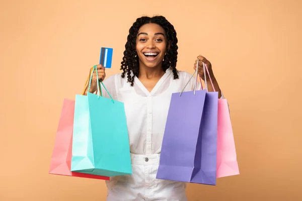 Africana chica celebración de tarjetas de crédito y bolsas de compras, Studio Shot —  Fotos de Stock