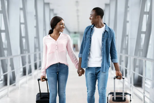 Net getrouwd zwart paar wandelen met koffers in de luchthaven, gaan naar huwelijksreis — Stockfoto