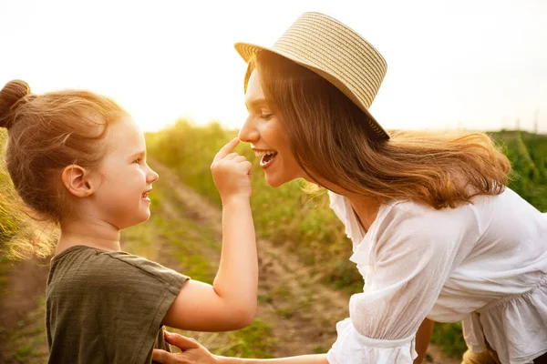 Glad mamma och barn leker tillsammans på vårfältet — Stockfoto