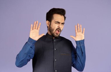 Reddedildi. Duygusal Hintli adam menekşe arkaplan üzerinde DUR hareketi gösteriyor