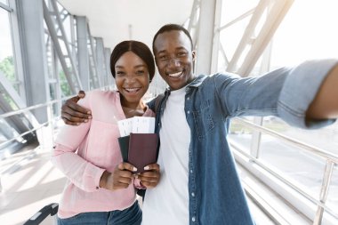 Birlikte seyahat ediyoruz. Mutlu Afrikalı çift havaalanında selfie çekiyor.