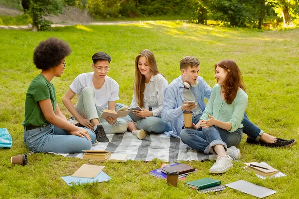 Tempo livre no campus. Grupo de estudantes universitários relaxando no gramado ao ar livre — Fotografia de Stock