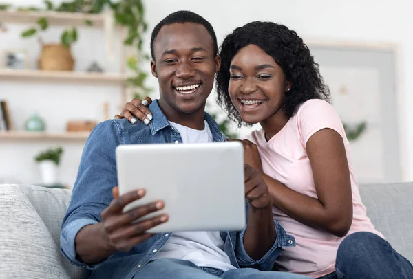 Emotionales afrikanisches Paar nutzt digitales Tablet gemeinsam zu Hause — Stockfoto