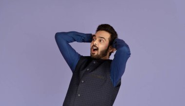 Kafasını tutup bağıran Hintli adam Violet stüdyosunun arka planında